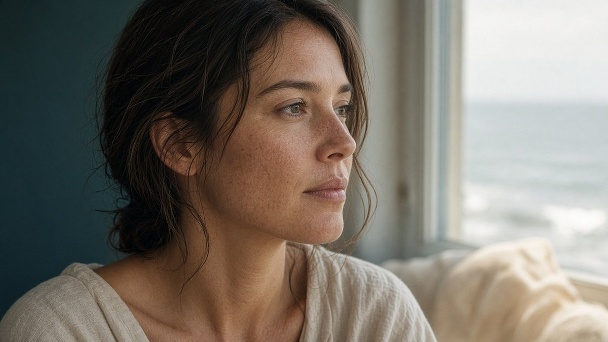 Woman with a natural profile looking out an ocean-view window